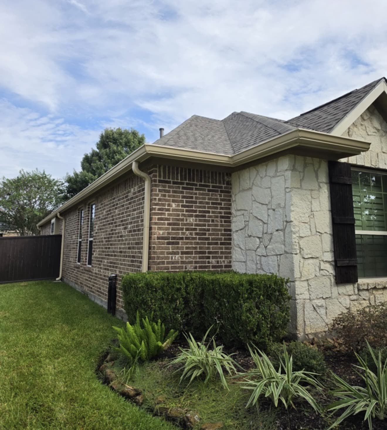 Brick and stone home with seamless gutters and downspouts
